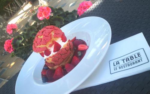 a white plate with a dessert with strawberries and blueberries at Logis Hotel Le Nouvel in Portes-lès-Valence