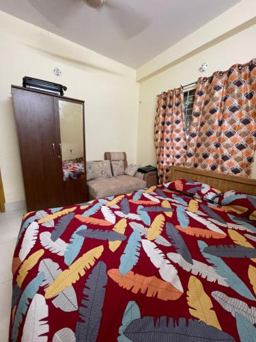 a bedroom with a bed with a colorful quilt at Your Home Away B&B in Sylhet
