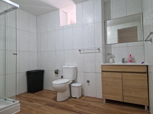 La salle de bains est pourvue de toilettes, d'un lavabo et d'un miroir. dans l'établissement Kaps Home - Tarrafal, à Tarrafal