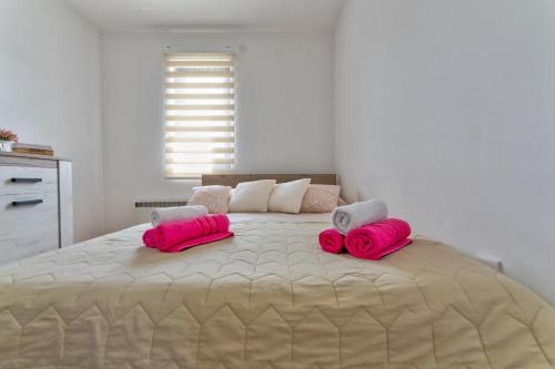 a large bed with two pink pillows on it at Mount Inn Studio in Zlatibor