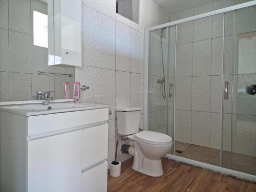 a bathroom with a toilet and a glass shower at Kaps Home - Tarrafal in Tarrafal