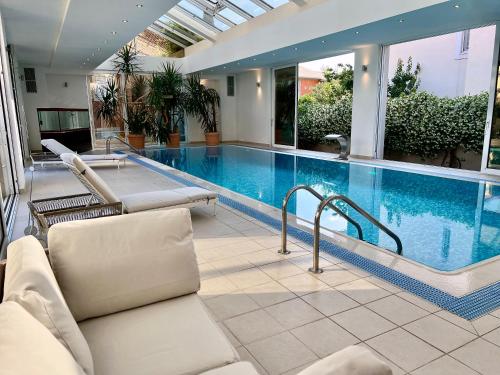 a swimming pool with chairs and a couch in a building at Villa Romana II Omis in Omiš