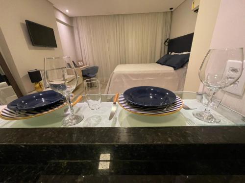 a table with plates and wine glasses on it at Flat localizado a 200m Shopping Recife, bem Perto da Praia de Boa Viagem e com Wi-Fi 400Mbps in Recife