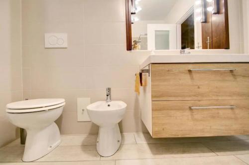 a white bathroom with a toilet and a sink at Casa di Giò in Pettenasco