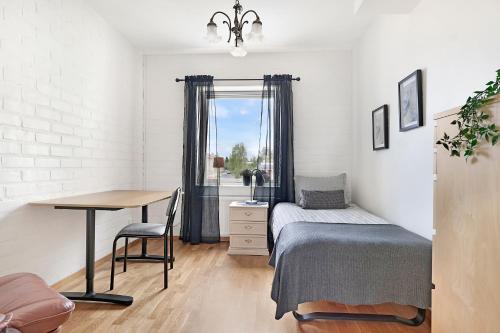 a bedroom with a bed and a desk and a window at Guestly Homes - 3BR City Charm in Piteå
