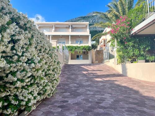 a walkway in front of a building with flowers at Villa Romana II Omis in Omiš
