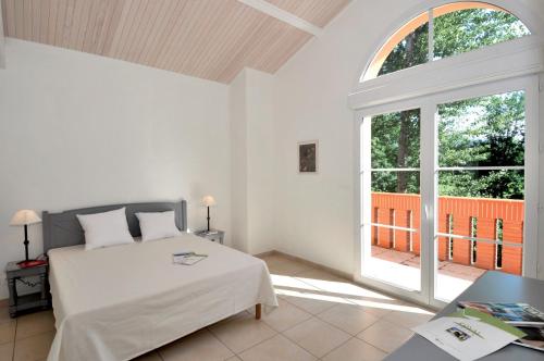 um quarto com uma cama e uma grande janela em Lagrange Vacances - Royal Green em Pont-de-Larn