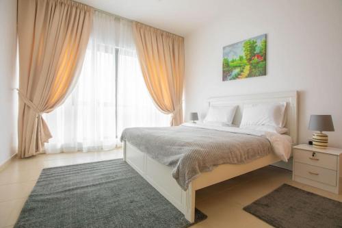 a white bedroom with a bed and a large window at SPACIOUS 3 Bedroom Apartm Beach Front (Side View) in Abu Dhabi