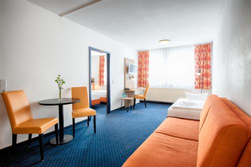 ドレスデンにあるACHAT Hotel Dresden Altstadtのベッド、テーブル、椅子が備わるホテルルームです。