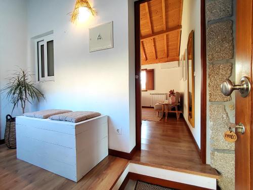 a room with a bed and a hallway with a door at Verde Água Agroturismo e Agricultura Biológica in Couto