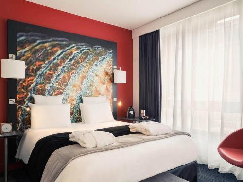 een hotelkamer met een groot bed met handdoeken erop bij Mercure Lille Centre Vieux Lille in Lille