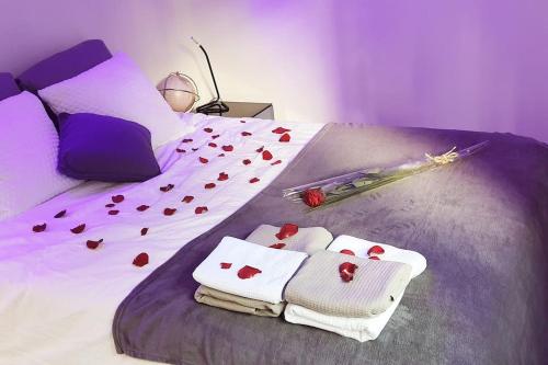 Una cama con corazones y toallas. en Marseille - Love House Jacuzzi - La Bonne Etoile ! en Marsella