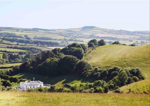 a house on a hill in a green field at The West Wing - Bride Valley - Jurassic Coast in Long Bredy