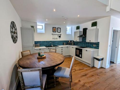 a large kitchen with a wooden table and chairs at The Livery Cottage at Cefn Tilla Court, Usk in Usk