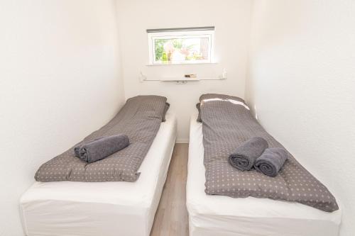 two beds sitting next to each other in a room at Parkvejens feriebolig in Bindslev