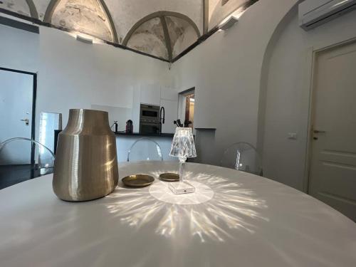 ジェノヴァにあるHappy Family Apartments Giustinianiの銀の花瓶が置かれたテーブル
