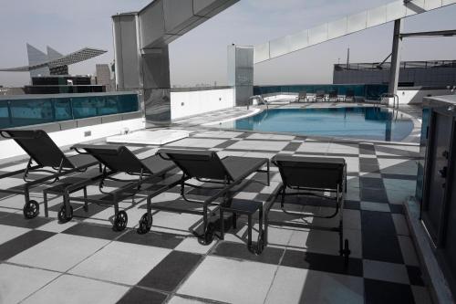 a patio with chairs and a pool on top of a building at SPACIOUS 3 Bedroom Apartm Beach Front (Side View) in Abu Dhabi