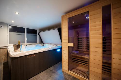 ein großes Bad mit einer Badewanne und einer Dusche in der Unterkunft Le COLVERT in Le Hanouard