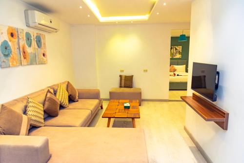 a living room with a couch and a tv at Jasmine Pyramids Hotel in Cairo