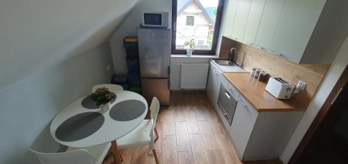 a small kitchen with a table and chairs and a sink at Pokoje Przy Polanie in Stronie Śląskie