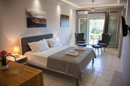 Schlafzimmer mit einem Bett, einem Tisch und Stühlen in der Unterkunft Dallas Hotel in Svoronata