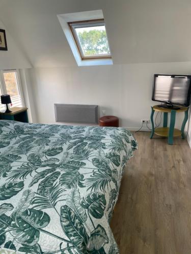 een slaapkamer met een bed met een groene en witte deken bij Ty Auguste, petite maison bretonne in Plobannalec-Lesconil