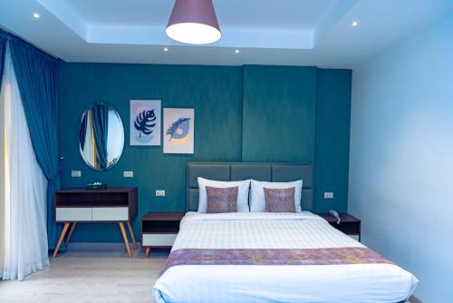 a bedroom with a large bed and a blue wall at Jasmine Pyramids Hotel in Cairo