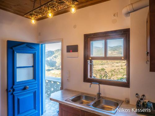 a kitchen with a sink and a blue door at Olympos apt with amazing mountain view in Olympos