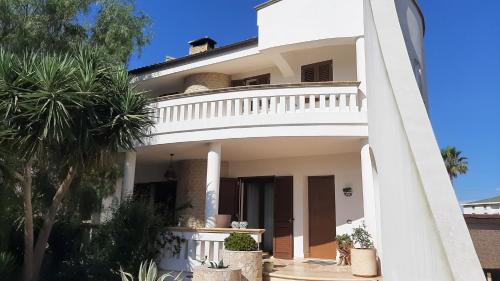 Casa blanca con balcón y palmeras en Casa Giulia, en Tiggiano
