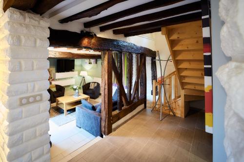 ein Wohnzimmer mit einem blauen Sofa und Holzdecken in der Unterkunft Le COLVERT in Le Hanouard