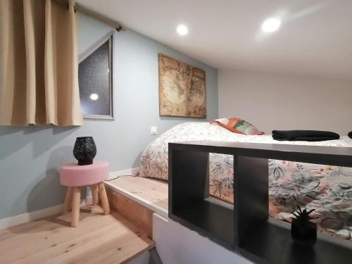 een woonkamer met een tv en een bed bij Le Grain de Sable, studio avec mezzanine in Tonneins