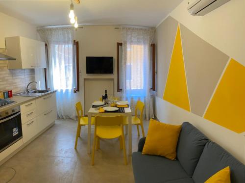 a kitchen and living room with a table and a couch at CasaBella Chioggia in Chioggia