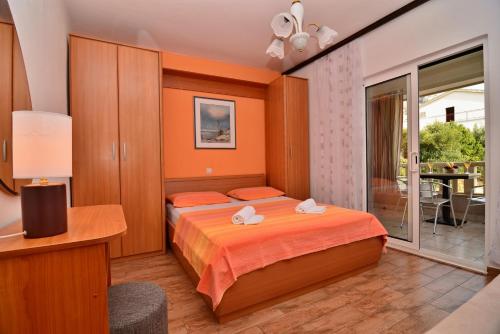 a bedroom with a bed and a balcony at Apartments Mustapic in Makarska