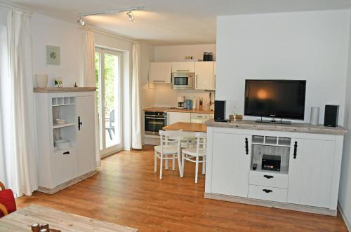 a living room with a kitchen with a tv on a cabinet at Ferienwohnung mit Balkon und Stran in Ostseebad Sellin