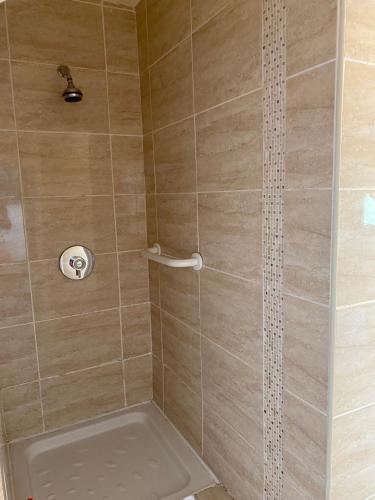 uma casa de banho com um chuveiro e uma banheira. em Clonmore Lodge B&B em Quilty
