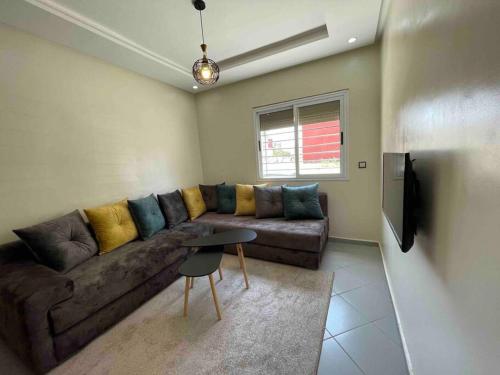 Fayb-Sweet-Home-2 - El-Wifaq في أغادير: غرفة معيشة مع أريكة بنية وطاولة