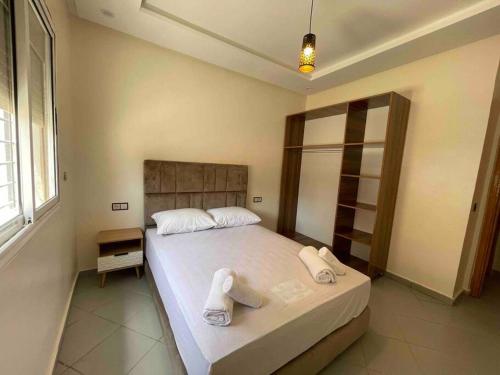 - une chambre avec un grand lit et des serviettes dans l'établissement Fayb-Sweet-Home-2 - El-Wifaq, à Agadir