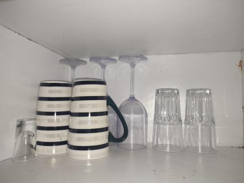 a group of glasses and wine glasses on a shelf at Classy Spacious Studio - Waiyaki Way in Rungiri