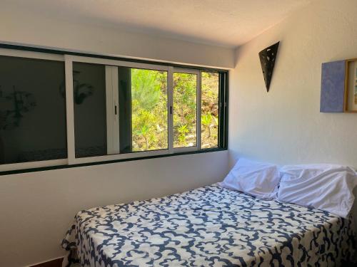 um quarto com uma cama e uma grande janela em Alfamar V3 Falésia Beach em Albufeira