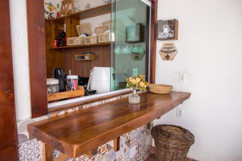 a wooden counter in a kitchen with a mirror at Casa 3 amores PREÁ, vento, charme, piscina e 2 quartos in Prea