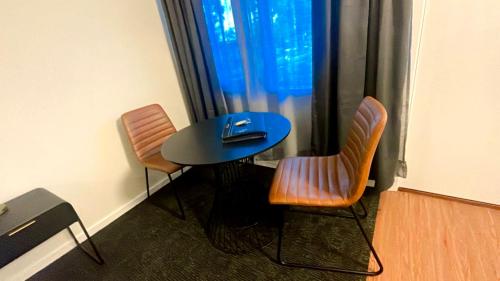 a table and two chairs in a room with a window at Seven Inn in Wagga Wagga