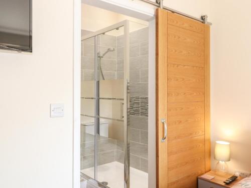 a shower in a bathroom with a glass door at The Granary in Wigton