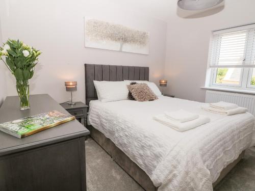 a bedroom with a bed with a vase of flowers on it at Beaus House in Cheltenham
