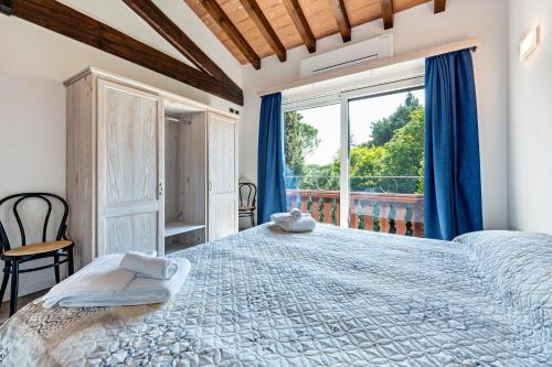 - une chambre avec un grand lit et une grande fenêtre dans l'établissement Al Segnavento Fasanella, à Toscolano Maderno