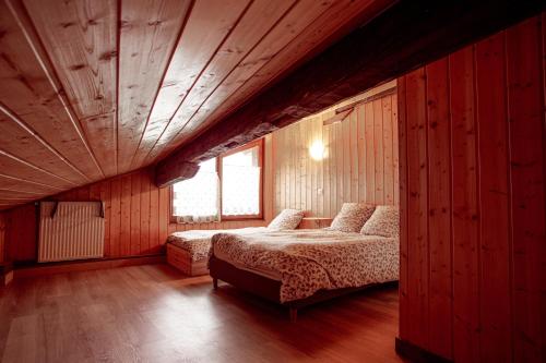 a bedroom with two beds and a large window at Maison 3 Vallées Val Thorens in Novallay