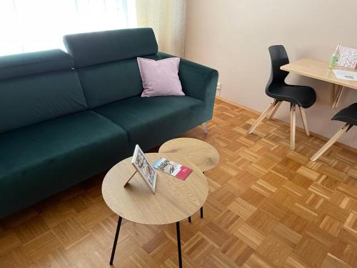 a living room with a green couch and a table at Ferienwohnung Stadtmitte Würzburg in Würzburg