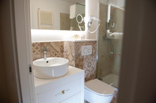 a bathroom with a sink and a toilet and a mirror at Residenza Catullo in Verona