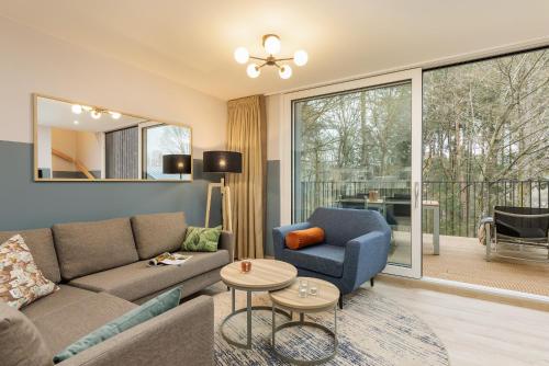 ein Wohnzimmer mit einem Sofa und einem Stuhl in der Unterkunft Center Parcs Eifel Mosel Nürburgring in Gunderath