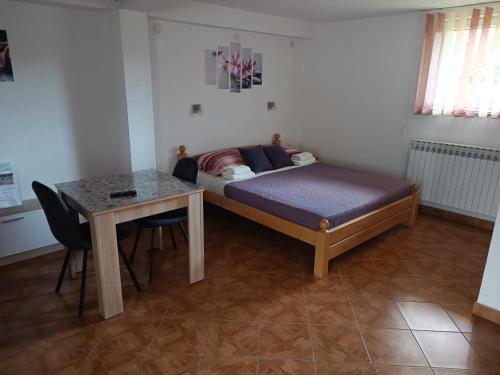 een kleine slaapkamer met een bed en een tafel bij Rooms Marijanović Plitvice in Vrelo Koreničko