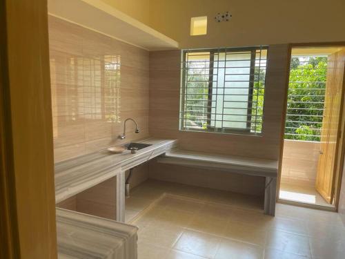 La salle de bains est pourvue d'un lavabo et d'une fenêtre. dans l'établissement Your home Away, à Sylhet